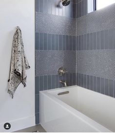 a bath tub sitting next to a window in a bathroom