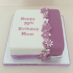 a white and purple birthday cake with flowers on the side that says happy 70thth birthday mam