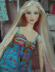 a doll with long blonde hair wearing a blue dress