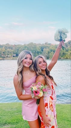 two young women are posing for the camera with their bouquets in front of them