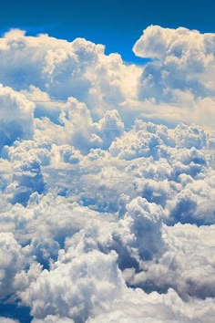 the view from an airplane window shows clouds and bright blue sky in the foreground