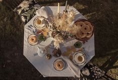 an overhead view of a table with food and drinks on it in the middle of a field