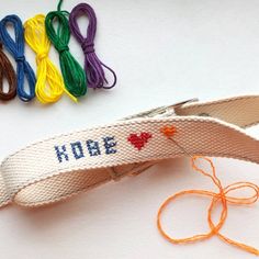 a pair of scissors sitting on top of a white table next to some colorful thread