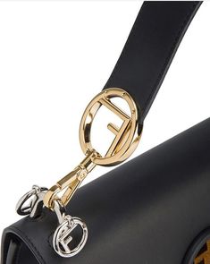 The FF logo is printed all over in velvet shades of black and brown on black calf leather.The handbag from Fendi features a foldover top with flip-lock closure, a top handle, a chain and leather strap, interior compartments divided by a partition and 2 tones hardware.The gusseted interior features a pocket and two compartments divided by a stiff partition. Can be worn cross-body or carried by hand thanks to the detachable shoulder strap with a mix of palladium-finish and gold-finish metalware Me Fendi Kan I, Ff Logo, Fendi Logo, Saint Laurent Bag, Velvet Bag, Timeless Handbag, Luxe Fashion, Casual Backpack, Fendi Bags