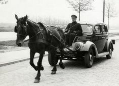 an old black and white photo of a horse pulling a car