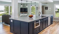 a large kitchen with an island in the middle and lots of windows on both sides