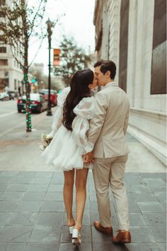 a man and woman kissing on the street