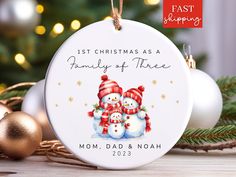 a christmas ornament with two snowmen on it and the words last christmas as a family of three