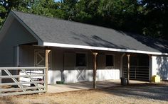 a white barn with two stalls and a gate