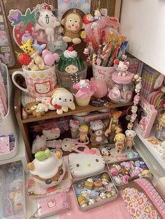 many hello kitty items are on display in a store shelf with other toys and decorations