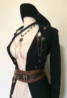 a mannequin wearing a black jacket and white dress with buttons on the collar