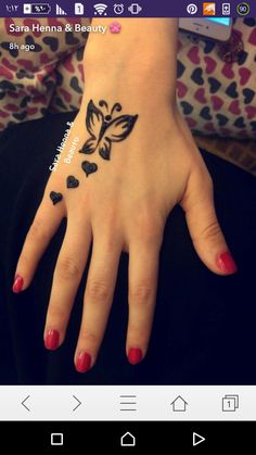 a woman's hand with black hearts on it and a butterfly tattooed on the wrist