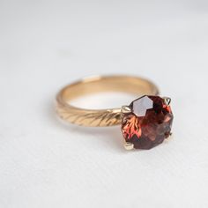 A One of A Kind Custom Handcrafted Oregon Sunstone Ring in 14k Yellow Gold Size 7 featuring a large, faceted, dark red gemstone set in a four-prong setting. Oregon Sunstone Engagement Ring, Accessories Capsule, Sunstone Engagement Ring, Sunstone Ring, Engagement Necklaces, Oregon Sunstone, Gettin Hitched, Leaves Pattern, Falling Leaves