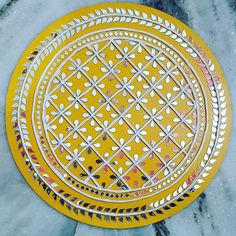 two yellow plates sitting on top of a marble counter next to a white and black tile floor