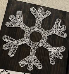 a string art snowflake is displayed on a table