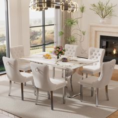 a dining room table with white chairs and a chandelier above it in front of a fireplace