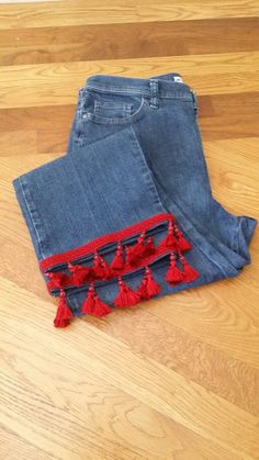 Restyled JEANS with Red TASSEL FRINGE, Women's Size 14 I created this look using a pair of Lee Classic Fit jeans and added Red Tassel Fringe with Beads to the hem. All of the reconstructed denim items I make are one-of-a-kind! Jeans 72% Cotton, 27% Polyester, 1% Spandex This pair of jeans will need to be dry cleaned or gently hand washed because of the tassel fringe. Size on tag: Lee, Classic fit, Size 14 Inseam 25 inches to the bottom of the hem. The tassels hang 1 3/4 inches below the hem. Rise 12 inches (Rise is the distance from the middle of the crotch seam to the top of the waistband). Length (measured at the side seam, from waist to hem) 37 inches  Measurements across while flat: Waist 17 inches Contact me if you do not see the item you want in the right size or if would like to kno Reconstructed Denim, Womens Jeans, Beaded Fringe, Tassel Fringe, Fit Jeans, Jeans Fit, Favorite Outfit, Tassels, Bathing Beauties