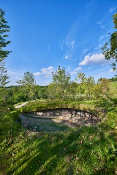 the circular structure is surrounded by trees and grass