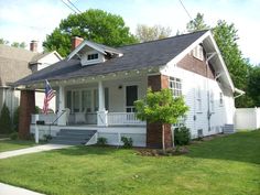 a small white house sitting on top of a lush green field