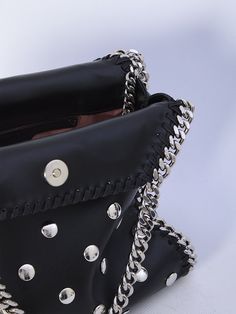 This black vegan fabric Falabella mini tote bag is adorned with all-over studs. It boasts a silver-tone diamond-cut chain, two top handles, one shoulder strap, magnetic closure, and one main interior compartment with an additional slip pocket.    Dimensions: 10x9.2x3.9 inches   Vegan fabric  All over studs  Two top handles  Magnetic closure  Slip pocket  Product code: 371223WP04541000  Composition: 51% polyester, 49% polyurethane Chic Studded Shoulder Bag, Chic Studded Shoulder Bag For Party, Evening Shoulder Bag With Studs, Chic Party Shoulder Bag With Studs, Studded Evening Shoulder Bag, Chic Black Studded Shoulder Bag, Elegant Evening Shoulder Bag With Rivets, Studded Leather Party Bag, Leather Party Bag With Studs