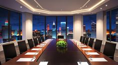 an empty conference room with city lights in the background