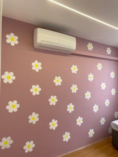 an air conditioner mounted to the side of a wall with flowers painted on it