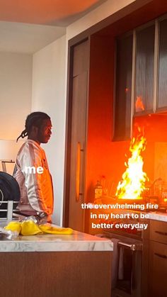 a man standing in front of a fire with his back turned to the camera and words above him