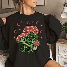 The perfect comfy and cozy mushroom crewneck sweatshirt is the ideal gift for any nature or mycophile lover, for the ideal  Christmas present for mom, family members, best friend, or any occasion to put a smile on their faces! Item Details: Gildan 18000 8.0 oz., pre-shrunk 50% cotton, 50% polyester Classic fit with no center crease Air-jet spun yarn with a soft feel and reduced pilling 1x1 athletic rib knit collar, cuffs and waistband, with spandex Tear away label Care Instructions: Machine wash Mushroom Print Tops For Fall Streetwear, Casual Long Sleeve Top With Mushroom Design, Casual Mushroom Print Sweatshirt For Fall, Black Crew Neck Top With Mushroom Print, Casual Fall Sweatshirt With Mushroom Print, Christmas Present For Mom, Casual Crew Neck Sweatshirt With Mushroom Print, Fall Crew Neck T-shirt With Mushroom Design, Fall Mushroom Print Crew Neck Sweatshirt