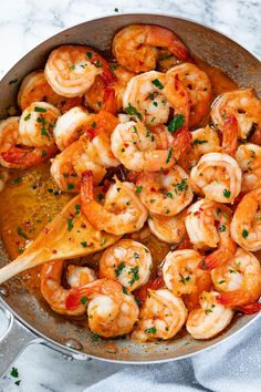 a skillet filled with cooked shrimp and garnished with parsley