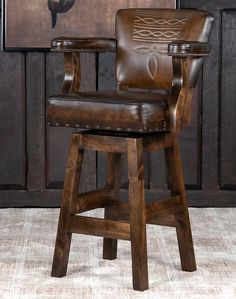 a brown leather bar stool sitting in front of a painting