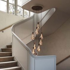 the light bulbs are hanging from the ceiling in the room next to the stair case