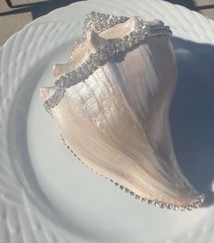 a white plate topped with a sea shell covered in diamonds