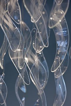 an abstract sculpture made out of clear plastic material with wavy lines on the bottom and sides