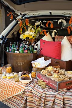 a trunk full of food and drinks in the back of a car