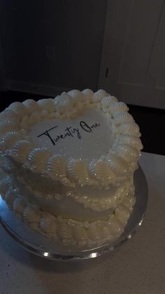 a white frosted cake sitting on top of a table