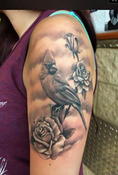 a woman with a bird and roses tattoo on her arm