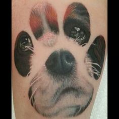 a close up of a dog's paw with red and white paint on it