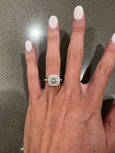 a woman's hand with a diamond ring on it