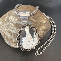 Masha Indian Native American Jewelry -On Route 66 - Albuquerque, New Mexico U.S.A Item Specifics           * Stone : White Buffalo Turquoise * Size : 20" * Pendant Size : 2.0" * Color : White with Matrix * Artisan : A T * SKU : 17036 * Metal : Sterling Silver * Metal Purity : 925 Genuine Sterling Silver Jewelry This beautiful Necklace is made from all 925 Sterling Silver Beads and Findings.  These Beads are meticulously hand strung and assembled by the artist creating the perfect balance of fall, color and shine. Necklaces are a must have for any collection, whether you are just starting out or are a serious collector you will not be disappointed with this work of art. These necklaces have excellent fall and can even be stacked with others, fashioned with a pendant or worn double wrapped t Southwestern Turquoise Necklace With Large Stone, Western Silver Engraved Necklaces, Western Style Silver Engraved Necklace, Western Style Engraved Silver Necklace, Silver Western Style Pendant Necklace, Western Style Silver Pendant Necklace, Silver Artisan Necklace With Concho, Artisan Silver Necklace With Concho, Western Style Silver Turquoise Necklace For Ranch