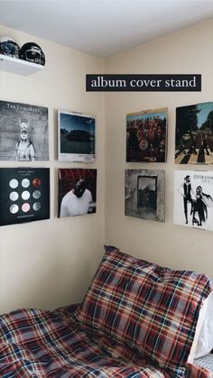 a bed sitting in a bedroom next to a wall with pictures on it and the words album cover stand above it