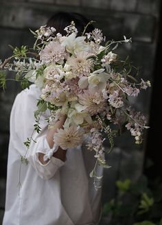 a woman holding a bouquet of flowers in her hands