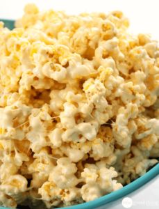 a blue bowl filled with popcorn on top of a table