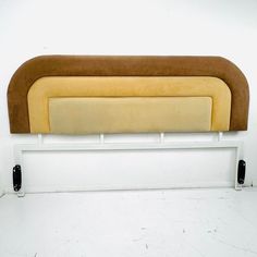 the back end of a couch that is sitting on top of a white shelf in a room