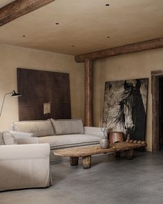 a living room filled with furniture and a painting on the wall