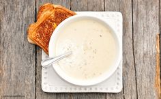 a bowl of soup and two pieces of bread on a plate