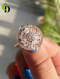 a close up of a person's hand holding a ring with diamonds on it