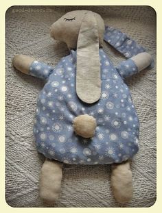 a stuffed animal laying on top of a bed covered in blue and white polka dots