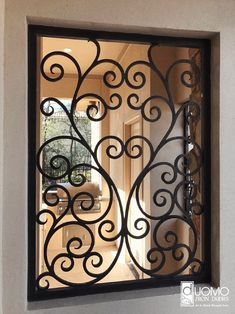 an iron gate is seen through the glass in front of a door that leads to a hallway