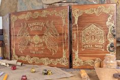 two wooden boxes sitting on top of a table next to some paper and pencils