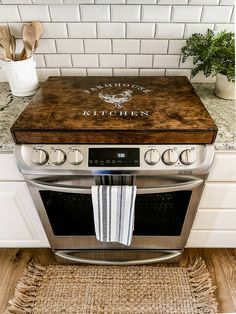 a kitchen stove with a wooden cutting board on top